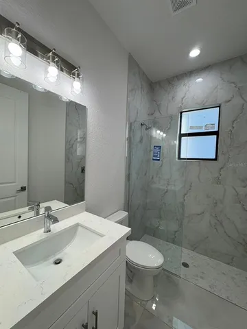 a bathroom with a toilet a sink and mirror