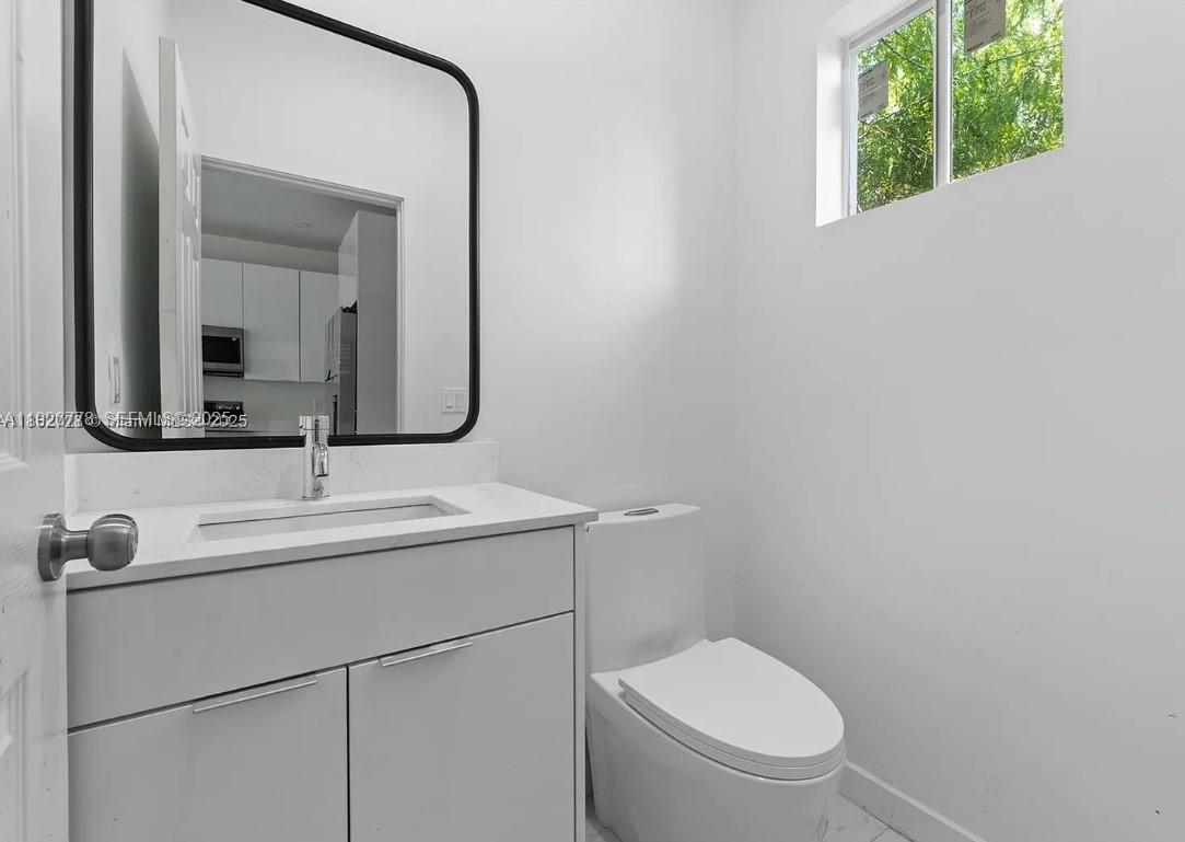 2145 Northwest 4th Street, Unit 2145 Pompano Beach, FL 33069 - Photo 3 of 13 a bathroom with a toilet sink and mirror