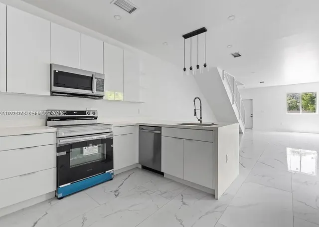 a kitchen with granite countertop a sink and a stove top oven