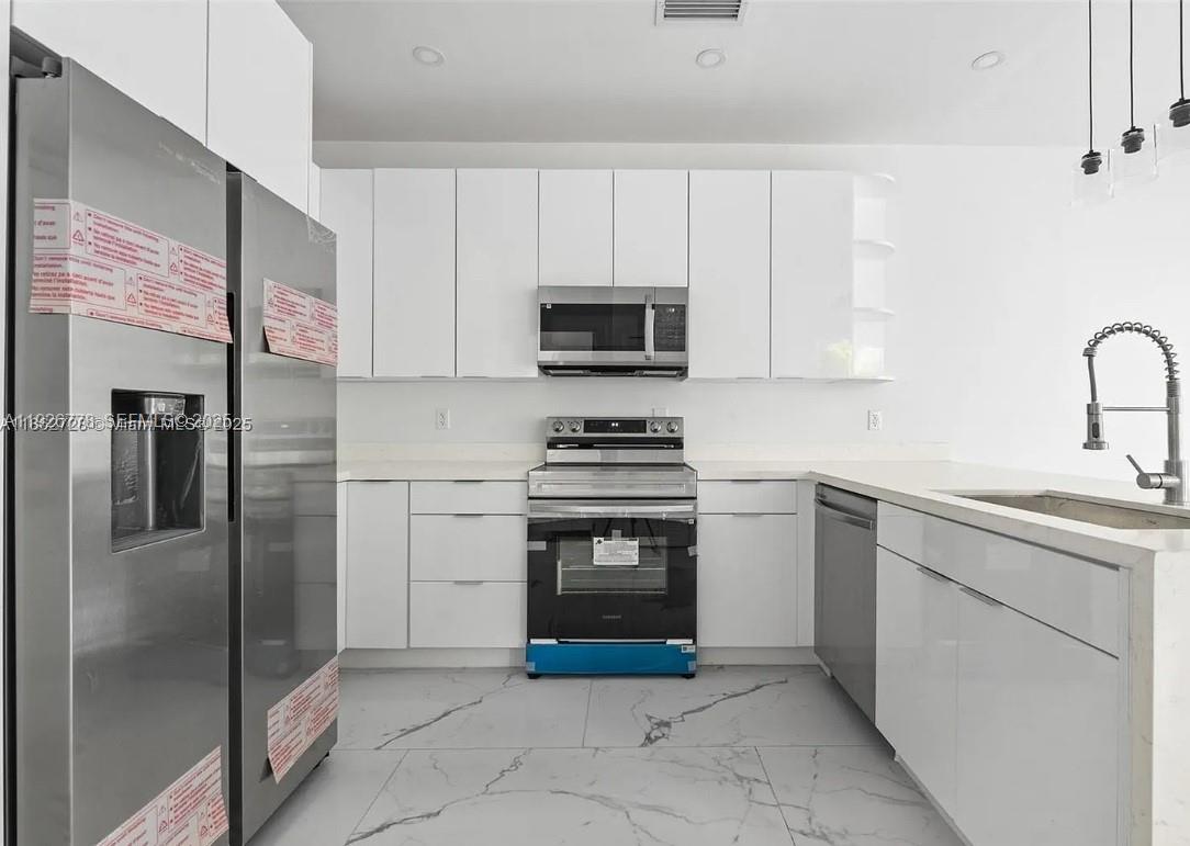 2145 Northwest 4th Street, Unit 2145 Pompano Beach, FL 33069 - Photo 6 of 13 a kitchen with stainless steel appliances granite countertop a refrigerator and a stove top oven