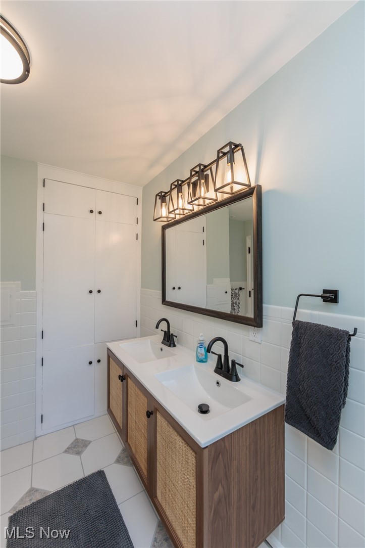 4944 Middledale Road Lyndhurst, OH 44124 - Photo 26 of 44 Full bathroom with a double sink, tile walls, and wainscoting