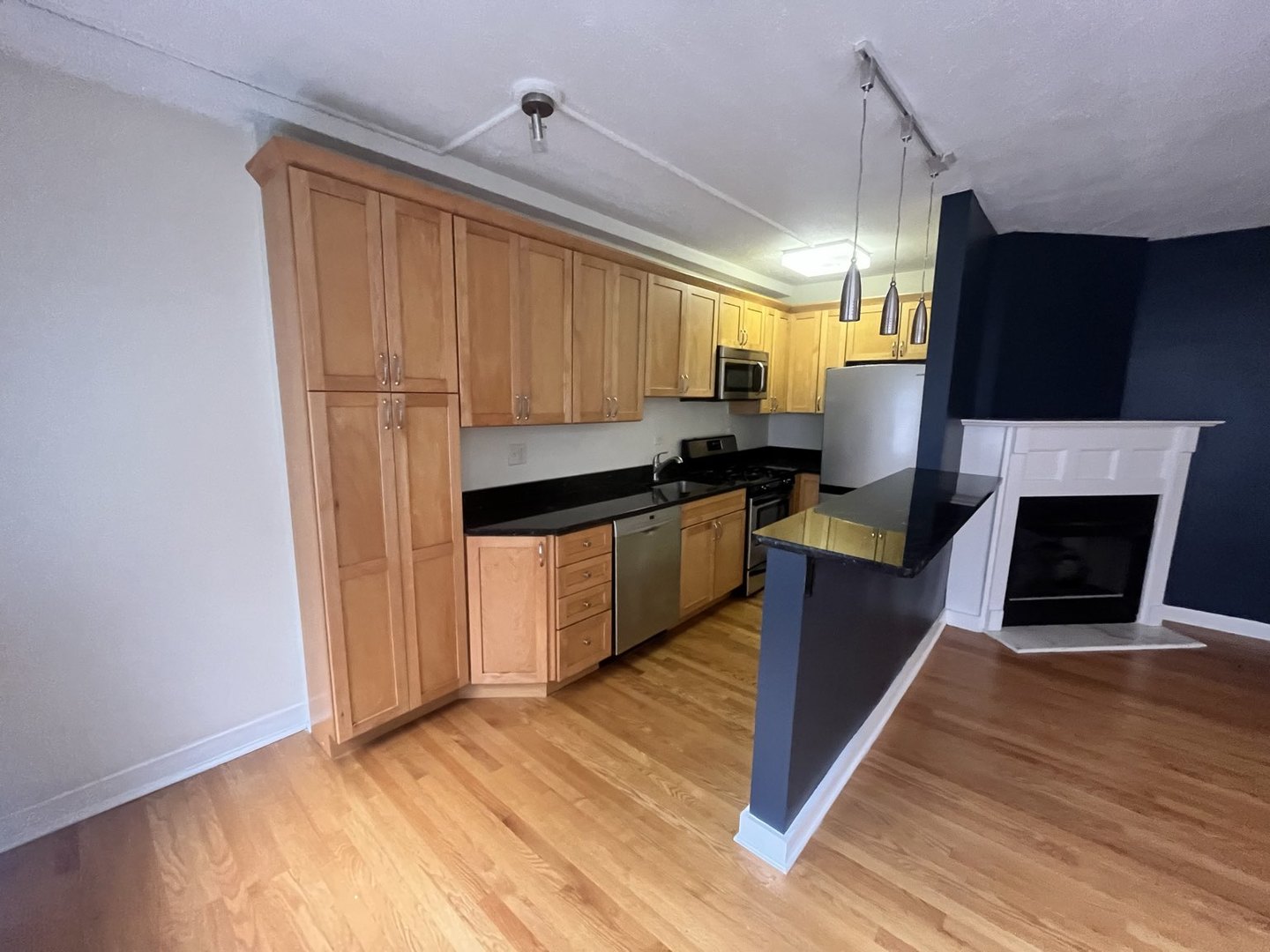 725 West Sheridan Road, Unit 402 Chicago, IL 60613 - Photo 11 of 31 a kitchen with kitchen island granite countertop a stove top oven a sink and a refrigerator