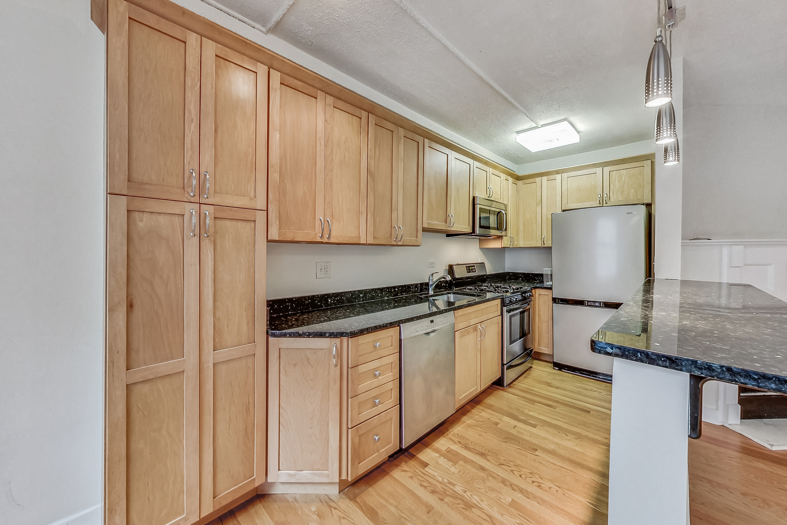 725 West Sheridan Road, Unit 402 Chicago, IL 60613 - Photo 12 of 31 a kitchen with granite countertop a sink appliances cabinets and counter space