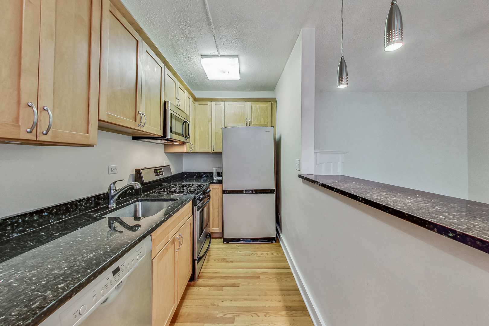725 West Sheridan Road, Unit 402 Chicago, IL 60613 - Photo 13 of 31 a kitchen with a sink and a stove top oven