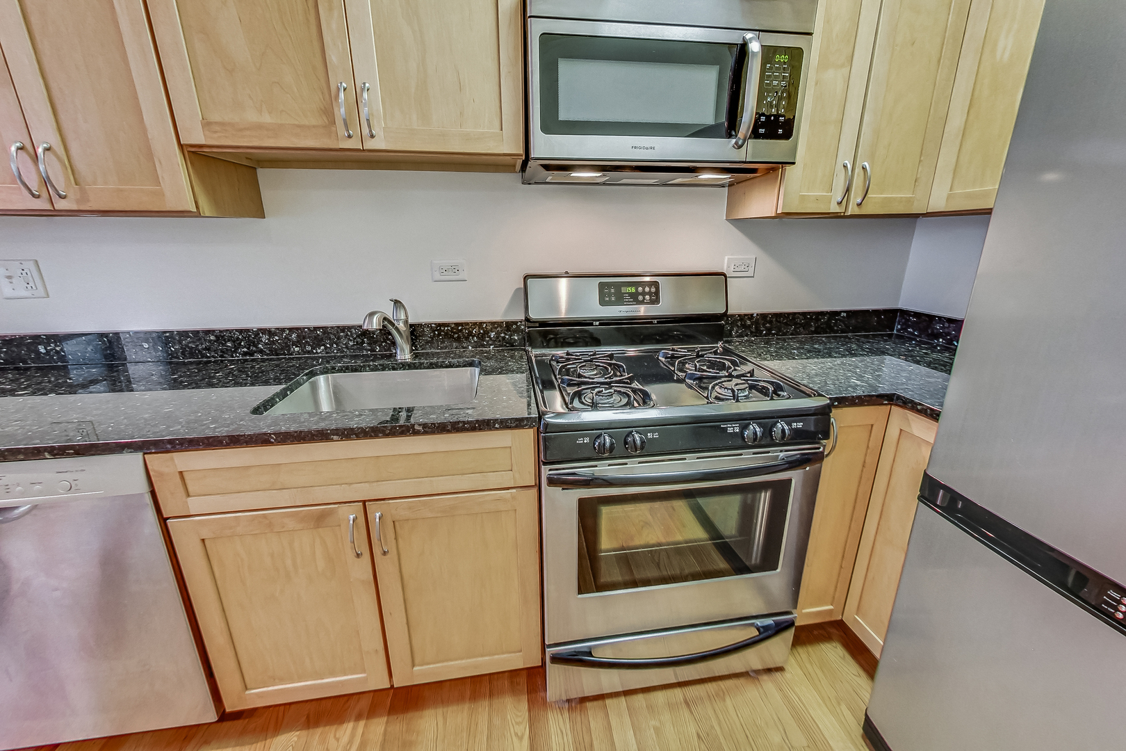 725 West Sheridan Road, Unit 402 Chicago, IL 60613 - Photo 14 of 31 a kitchen with stainless steel appliances granite countertop a stove a microwave and a sink