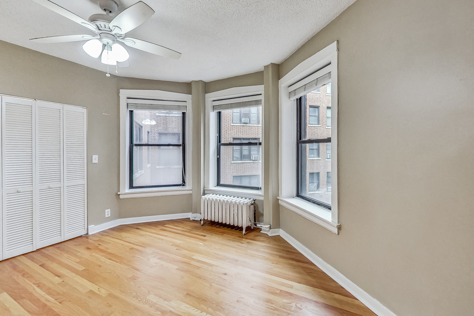 725 West Sheridan Road, Unit 402 Chicago, IL 60613 - Photo 16 of 31 an empty room with windows and ceiling fan