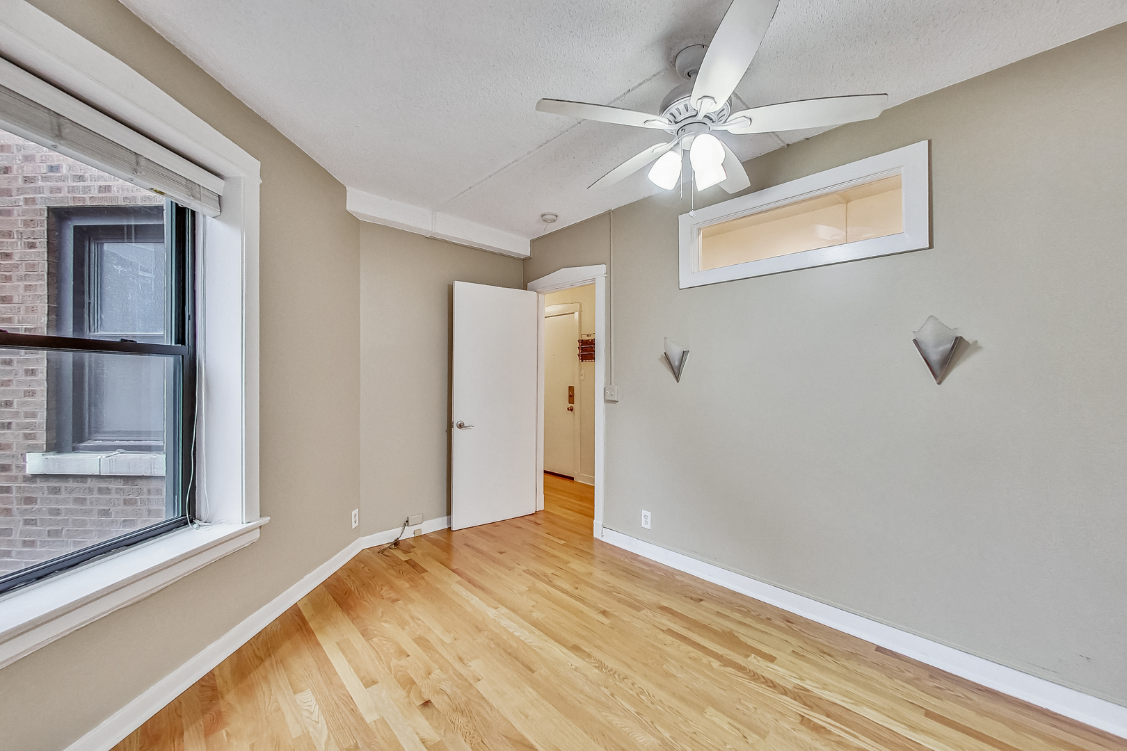 725 West Sheridan Road, Unit 402 Chicago, IL 60613 - Photo 18 of 31 a view of a bedroom with wooden floor and a ceiling fan