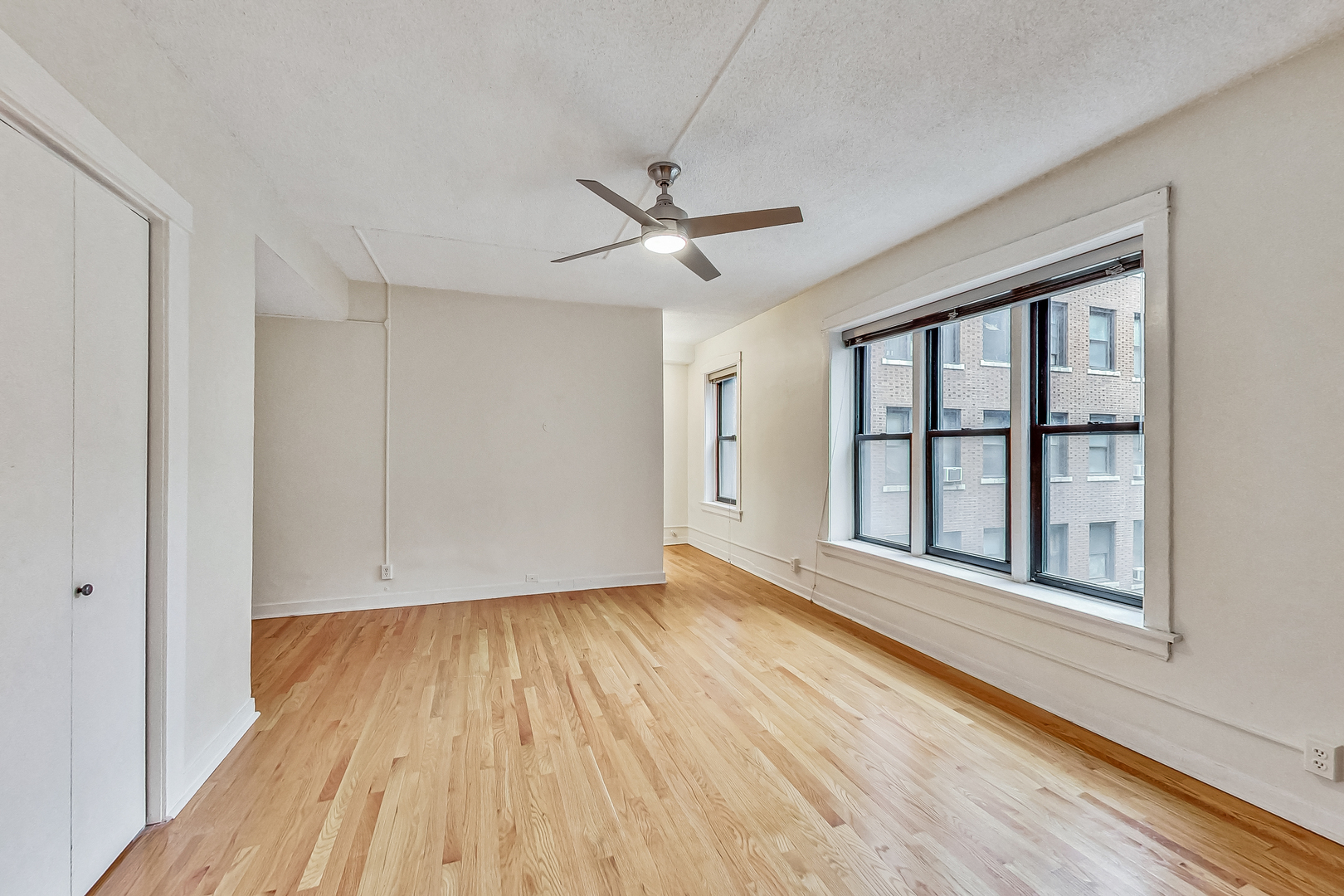 725 West Sheridan Road, Unit 402 Chicago, IL 60613 - Photo 21 of 31 wooden floor in an empty room with a window