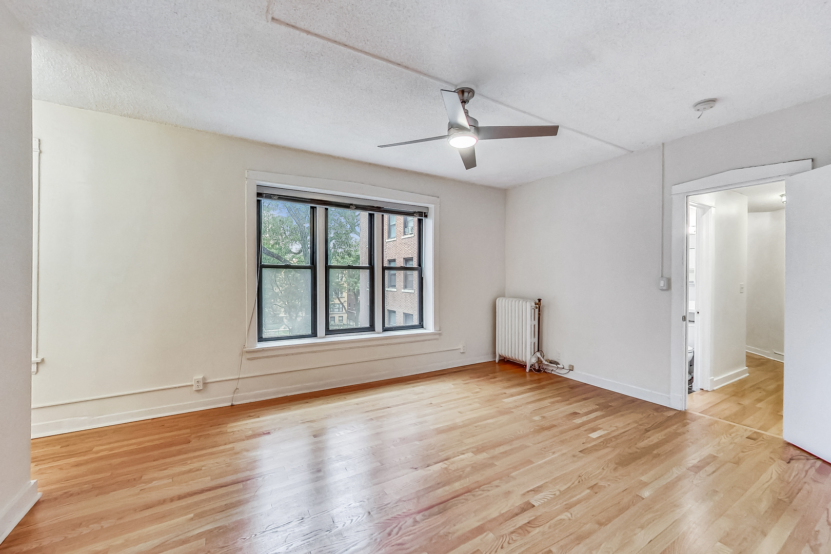 725 West Sheridan Road, Unit 402 Chicago, IL 60613 - Photo 24 of 31 a view of an empty room with wooden floor and a window