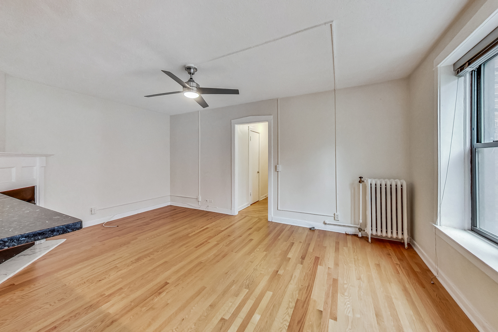 725 West Sheridan Road, Unit 402 Chicago, IL 60613 - Photo 9 of 31 a view of empty room with wooden floor and fan