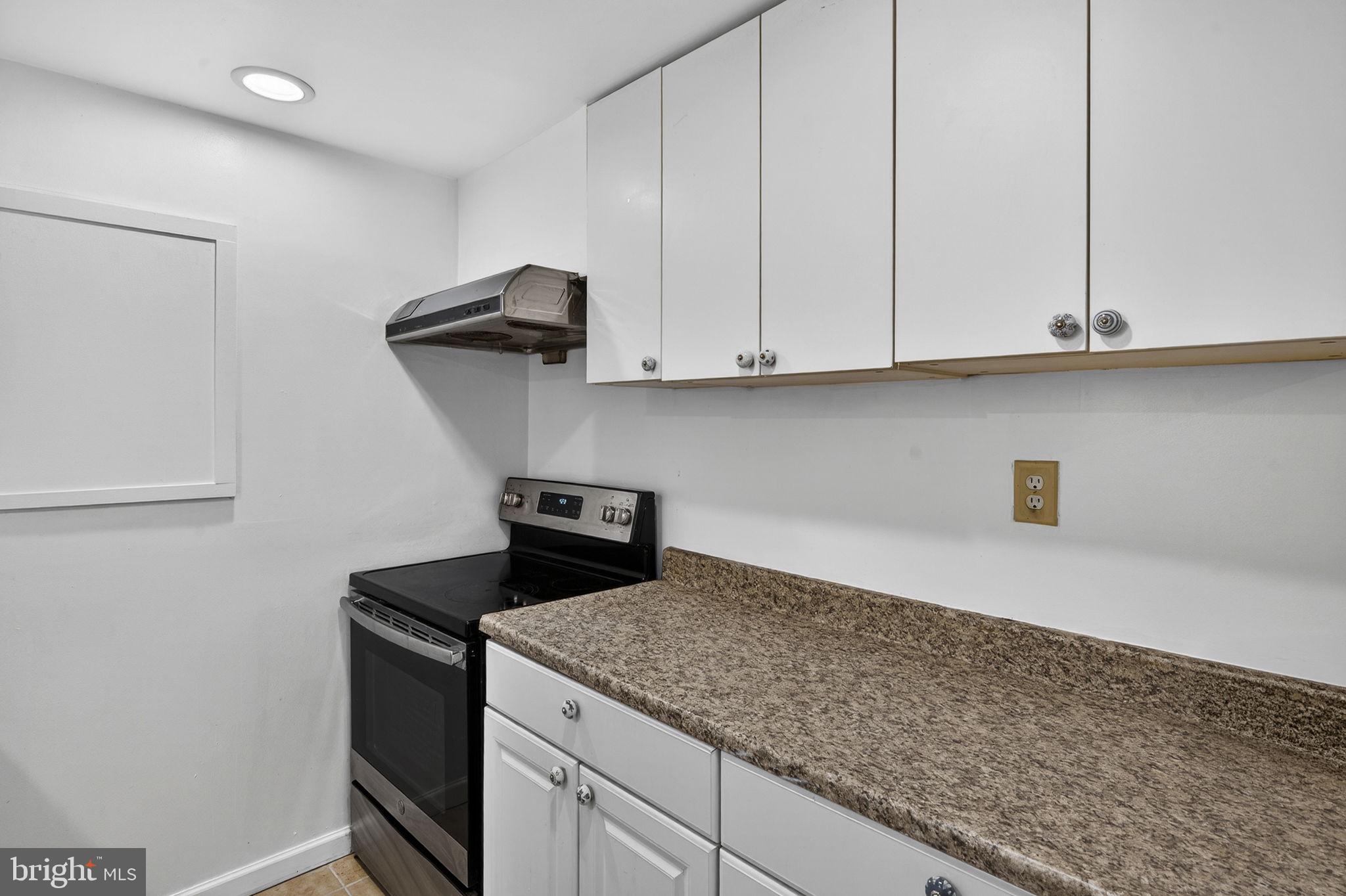 10600 Vantage Court Potomac, MD 20854 - Photo 66 of 91 a kitchen with granite countertop white cabinets and a stove