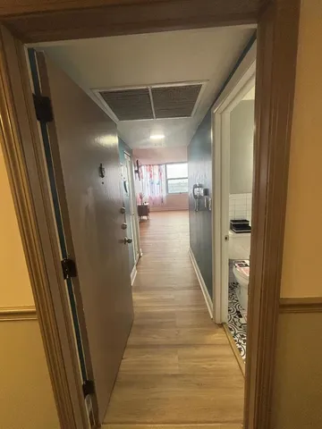 a view of a hallway with wooden floor