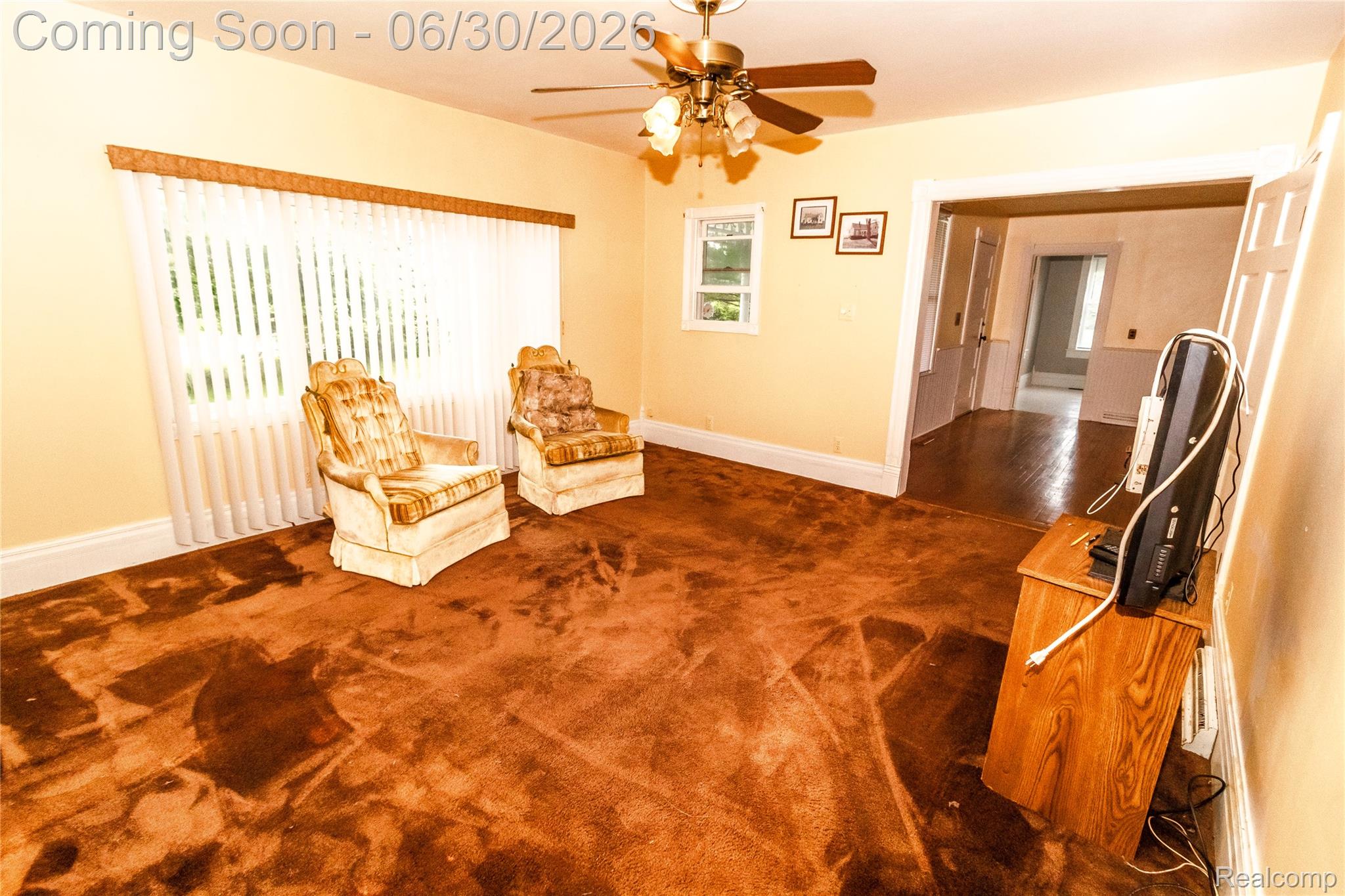 8150 Norman Road Imlay City, MI 48444 - Photo 22 of 58 Spacious room featuring multiple windows, a ceiling fan with light fixture, and an open doorway revealing wood-finish flooring in an adjacent area