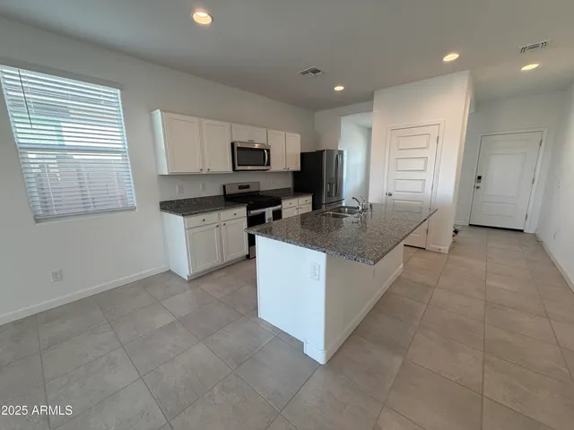 a kitchen with stainless steel appliances granite countertop a stove a sink and a refrigerator