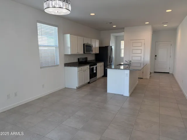 a large kitchen with a counter top space appliances and cabinets