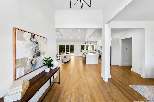 a large room with stainless steel appliances lots of white furniture a dining table and chairs