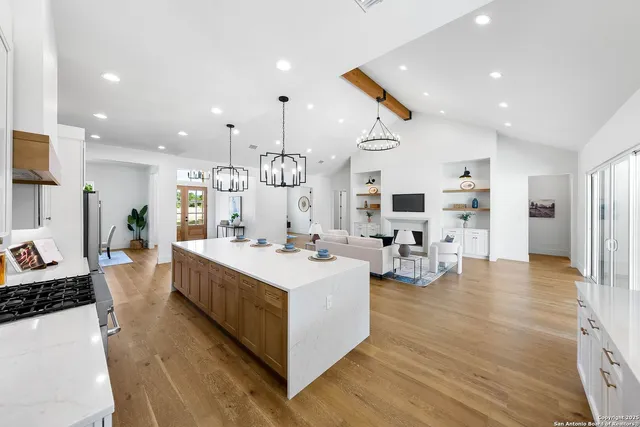 a living room with furniture kitchen view and a wooden floor