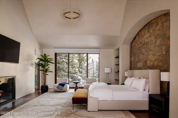 a bedroom with furniture a flat screen tv and a fireplace