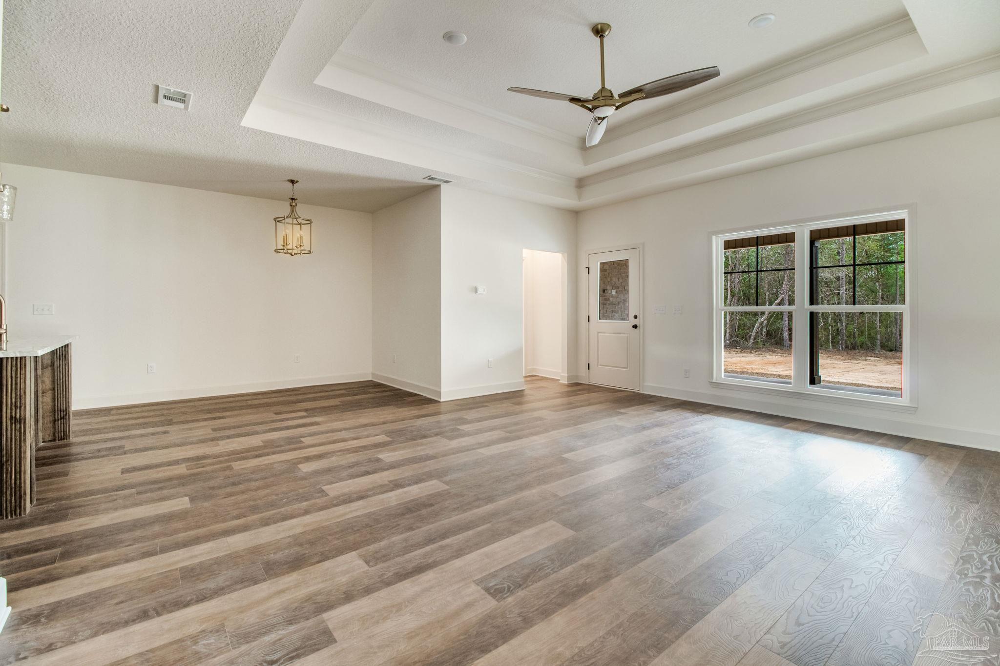 4310 Watkins Street Pace, FL 32571 - Photo 21 of 58 an empty room with wooden floor and windows