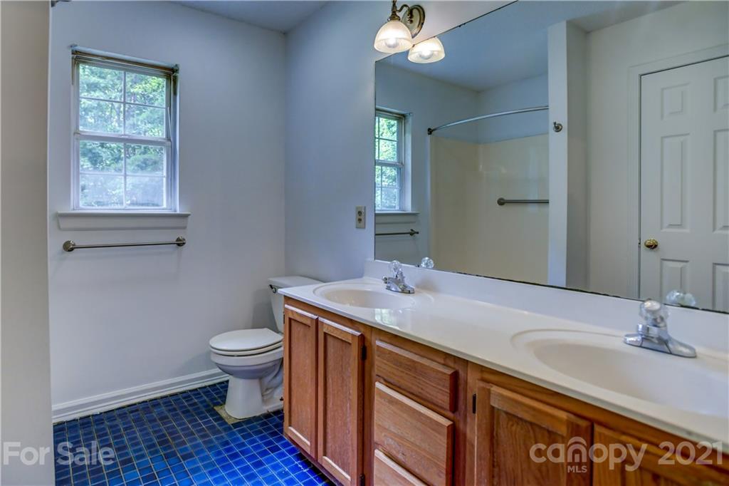 239 Valleyview Road Mooresville, NC 28117 - Photo 23 of 41 a bathroom with a granite countertop toilet a sink and a mirror