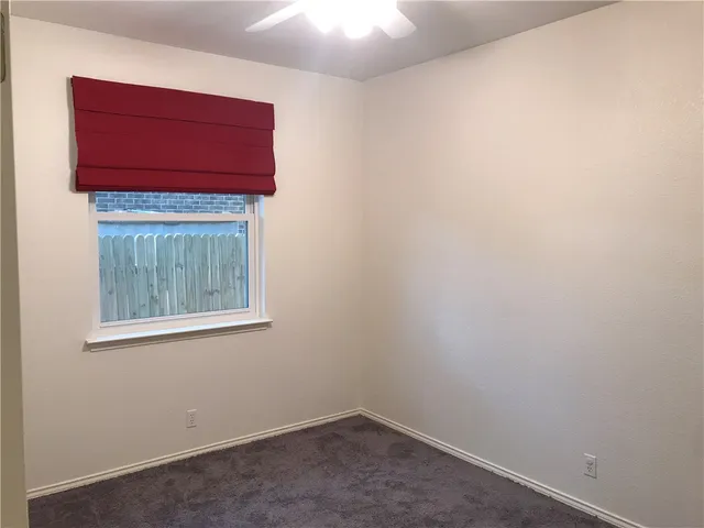 an empty room with a wooden door and a window
