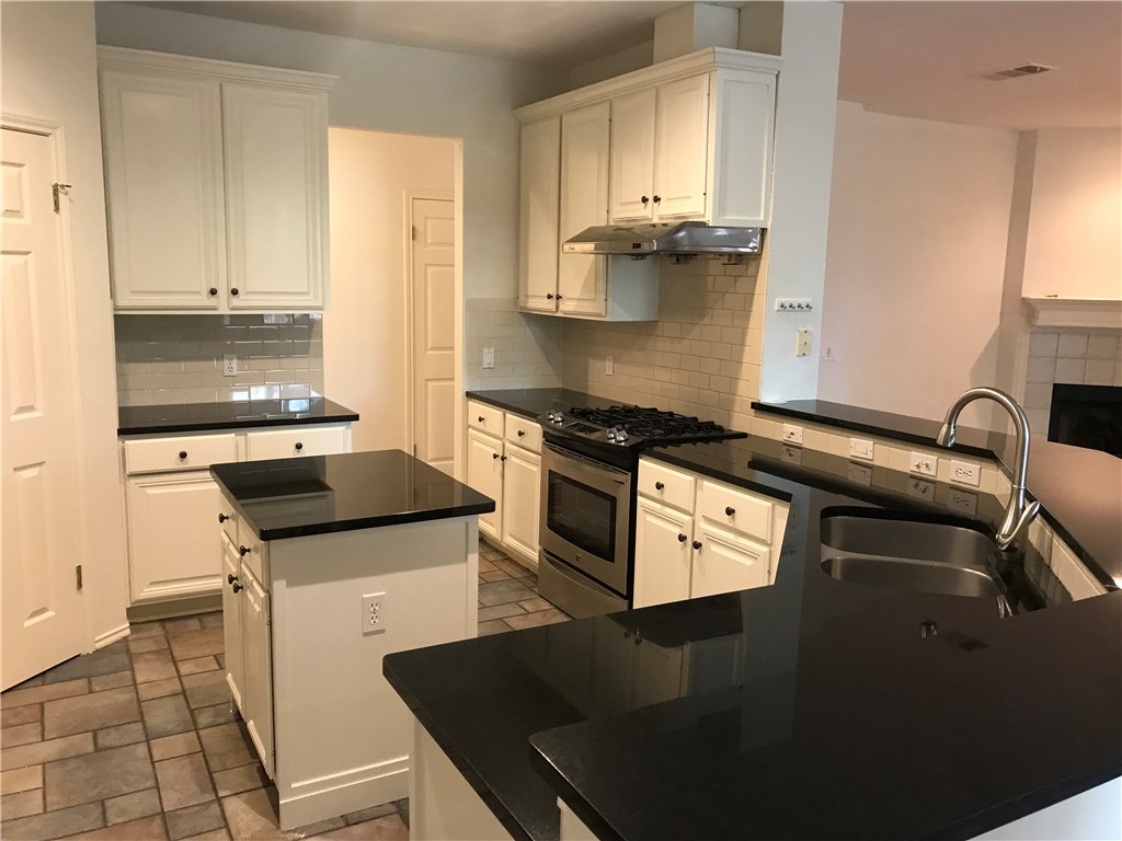6428 Ruxton Lane Austin, TX 78749 - Photo 5 of 23 a kitchen with a stove a sink and a refrigerator