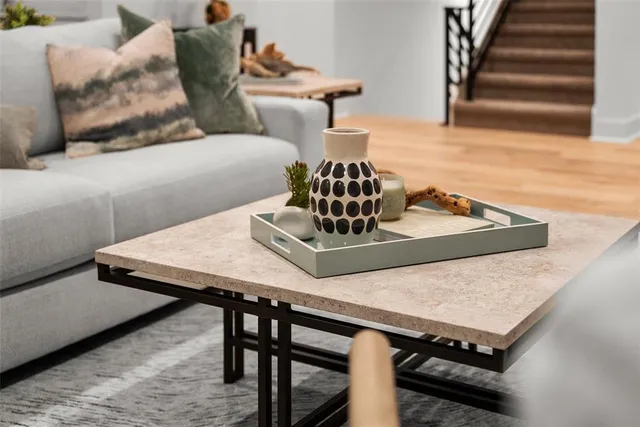 a kitchen with stainless steel appliances granite countertop a stove top oven a sink dishwasher a dining table and chairs with wooden floor