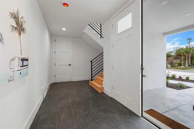 a kitchen with stainless steel appliances a dining table chairs stove refrigerator and cabinets