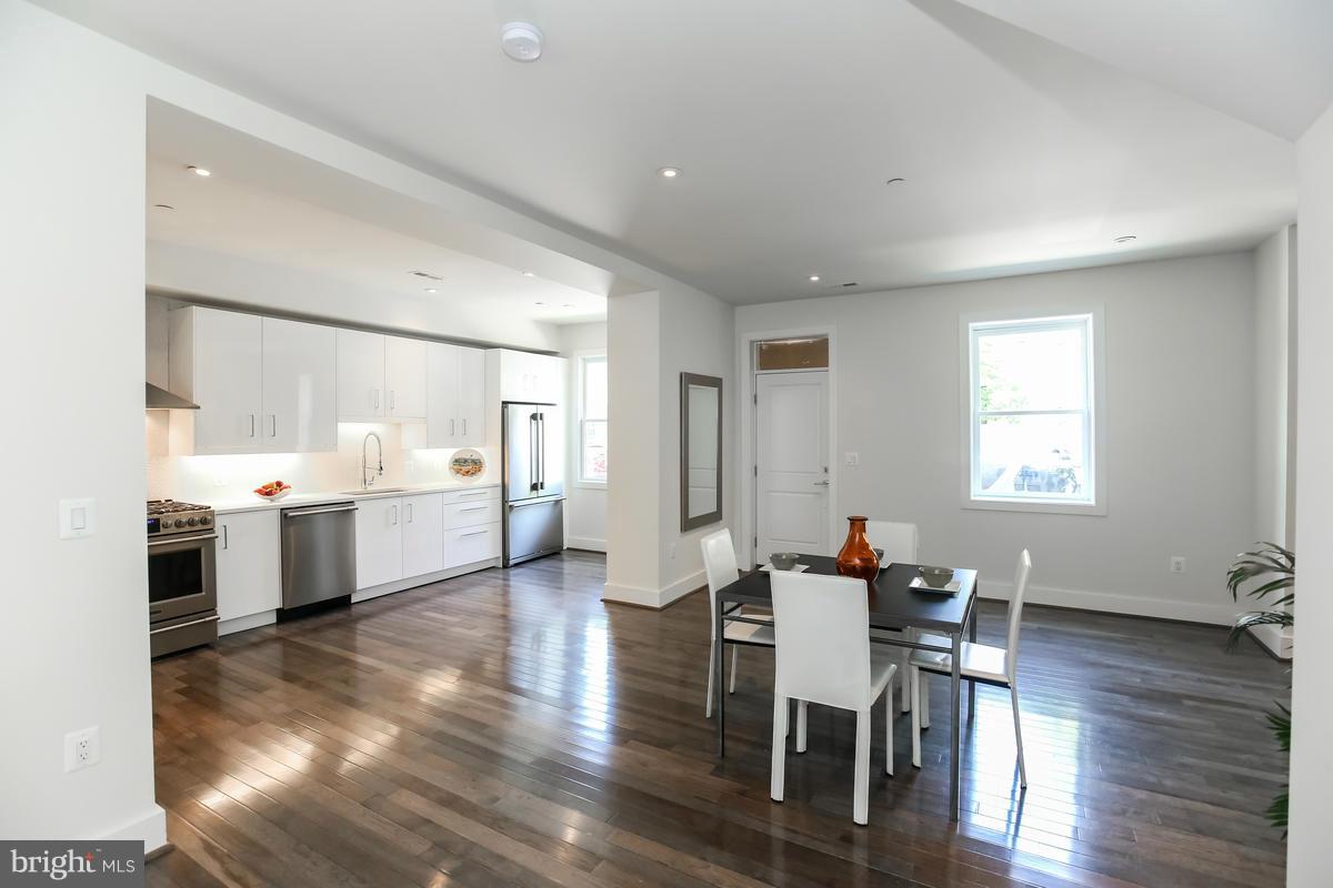 460 Ridge Street Northwest, Unit 1 Washington, DC 20001 - Photo 13 of 28 a large white kitchen with a table and chairs in it