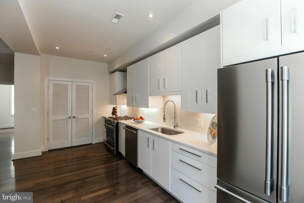 460 Ridge Street Northwest, Unit 1 Washington, DC 20001 - Photo 5 of 28 a kitchen with white cabinets and stainless steel appliances