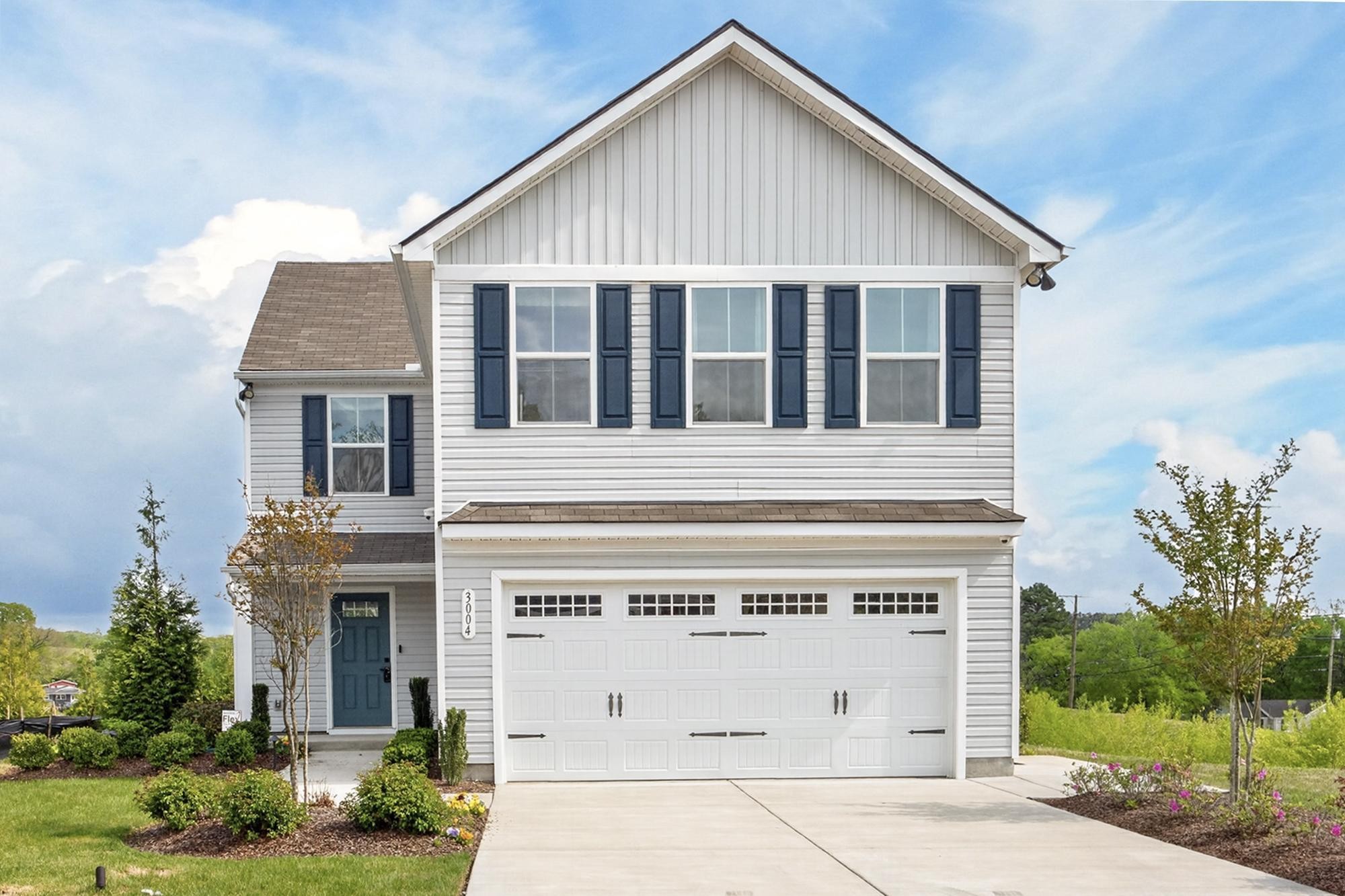 a view of a house with a yard and potted plants