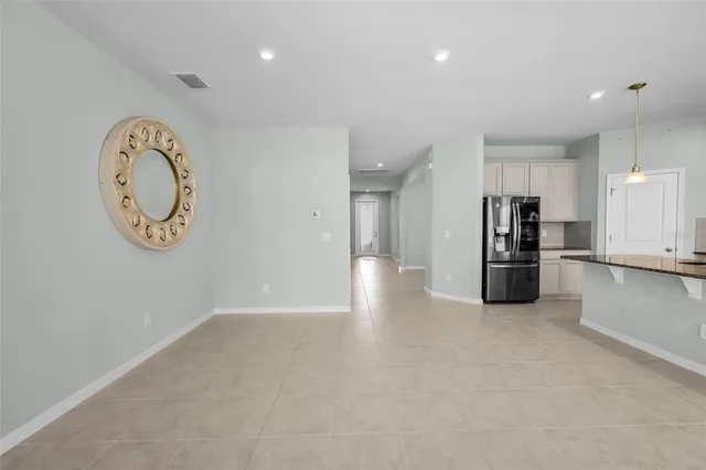 a view of a kitchen with fridge and wooden floor