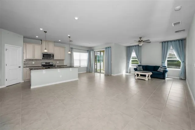 a view of a kitchen with a sink wooden cabinets and a window