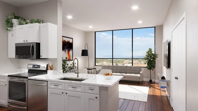 a kitchen with stainless steel appliances a sink counter space a large window and a view of living room