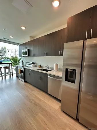 a kitchen with stainless steel appliances granite countertop a refrigerator stove and sink