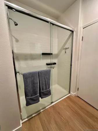a view of a hallway with wooden floor and closet