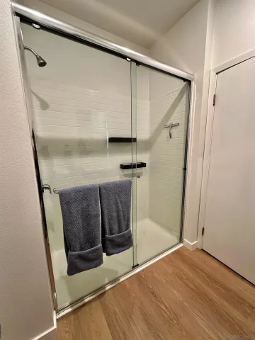 a view of a hallway with wooden floor and closet