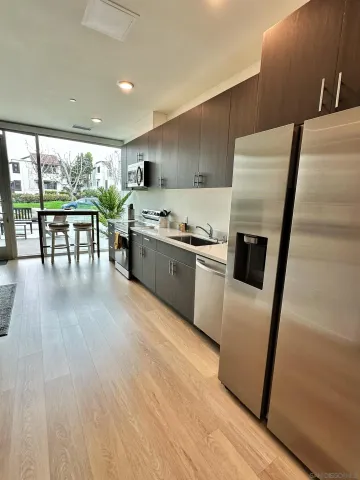 a kitchen with wooden floors and white stainless steel appliances