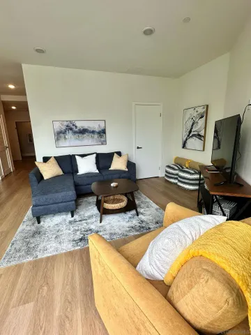 a living room with furniture and a wooden floor