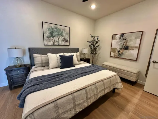 a bedroom with bed and paintings on the wall