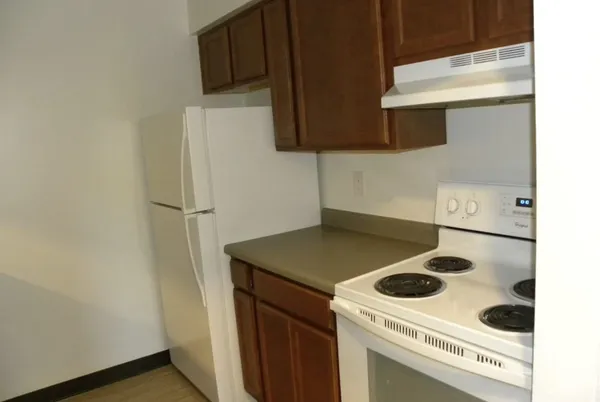 a kitchen with a refrigerator and a stove top oven