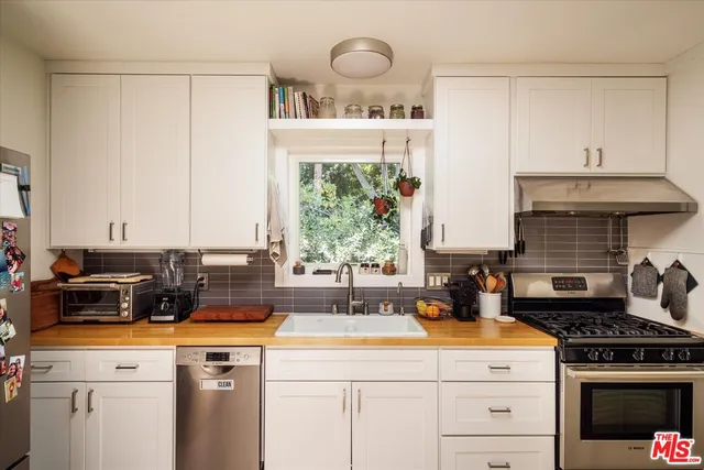 a kitchen with a stove a sink and a cabinets