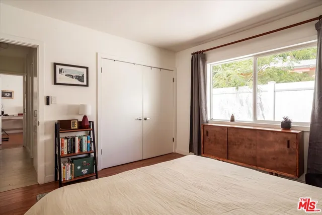 a bedroom with a bed and a large window