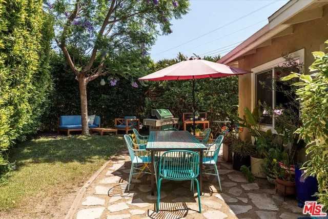 a view of a patio with chairs and table under an umbrella