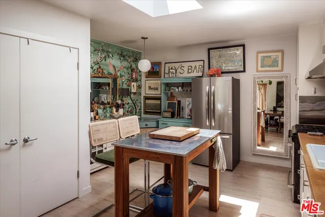 a kitchen with stainless steel appliances kitchen island granite countertop a refrigerator and a stove top oven