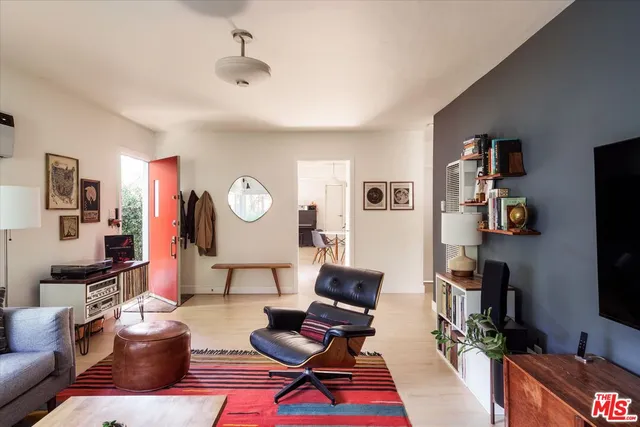 a living room with furniture a flat screen tv and a window