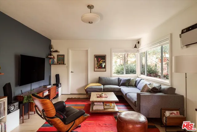 a living room with furniture a flat screen tv and a large window