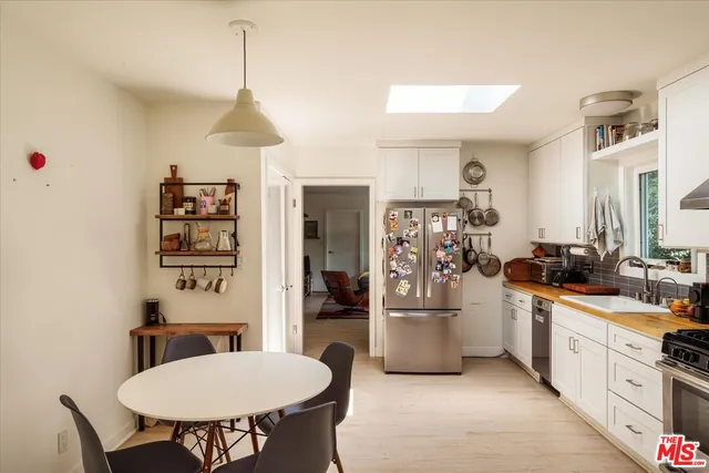 a kitchen with stainless steel appliances a sink a table and chairs