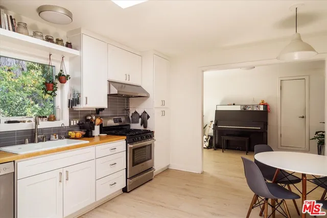 a kitchen with granite countertop a sink stainless steel appliances and cabinets