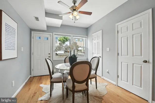 a dining room with furniture a chandelier and wooden floor